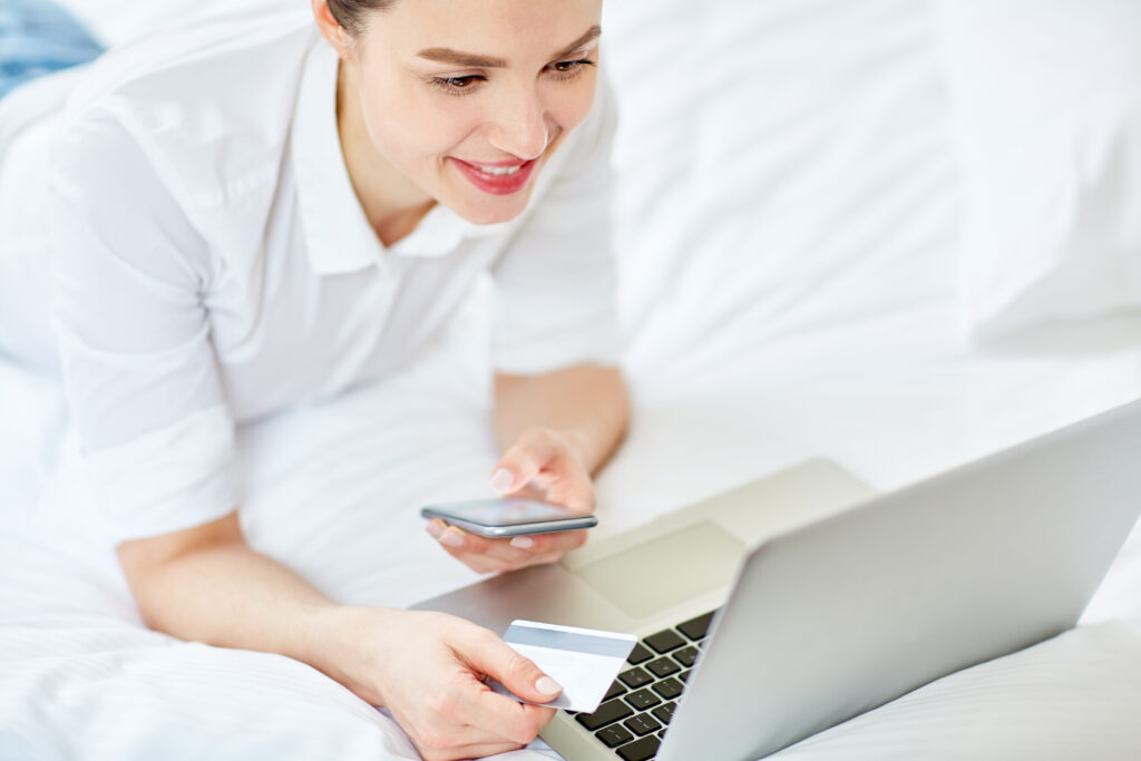 woman laying in bed online shopping